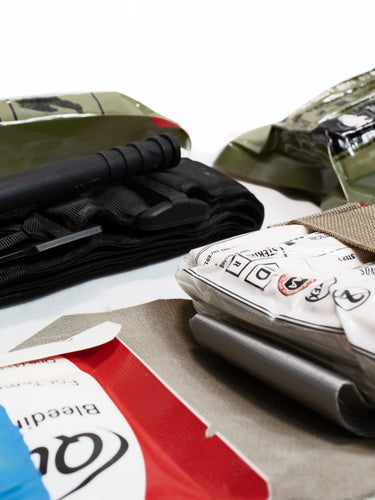 Close-up of tactical medical gear, including hemostatic gauze, chest seals, and tourniquet holders, essential for first responders and field medics in emergency scenarios.